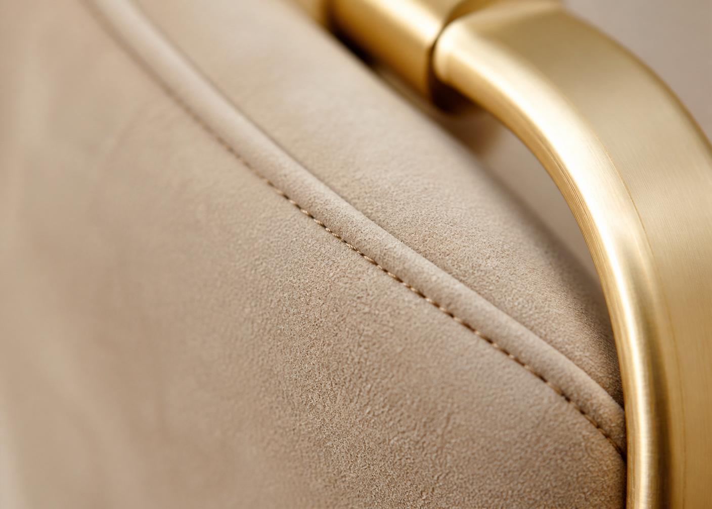 Macro detail of matte microfiber and brushed metal hardware